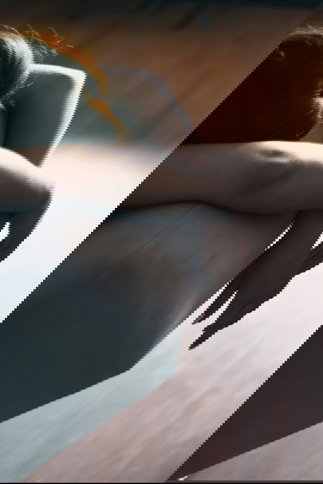 woman in black dress lying on gray couch